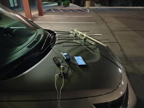 WD9EWK's portable FM satellite station before an ISS pass around 0810 UTC on 15 March 2026 in DM33 (Phoenix, Arizona): Anytone AT-D890UV, Elk Antennas handheld 2m/70cm log periodic, Sony audio recorder, mobile phone with AmsatDroid satellite tracking app.